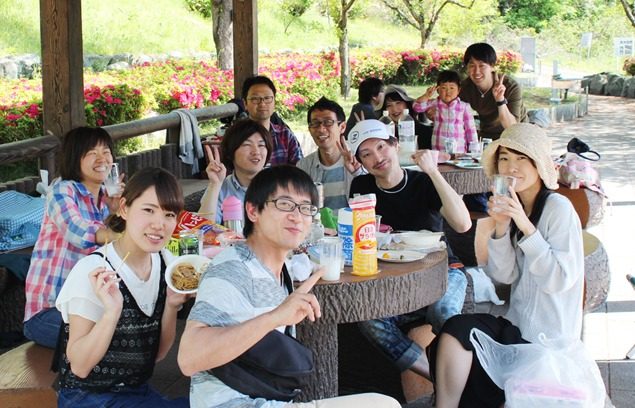 東屋のテーブルを囲んで食事を楽しむグループ