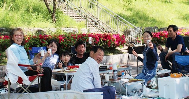 花壇のそばに椅子を並べてくつろぐグループ
